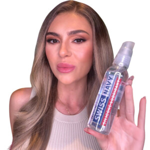 Person holding Swiss Navy lubricant bottle.