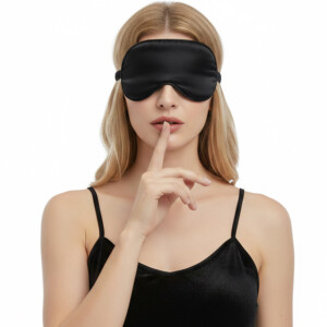 Woman wearing black sleep mask, gesturing silence.