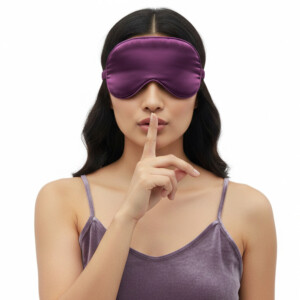Woman wearing purple sleep mask, shushing gesture.