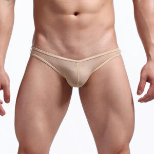 Male model wearing beige bikini briefs against white background