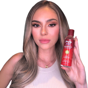 Woman holds bottle of warming lubricant.