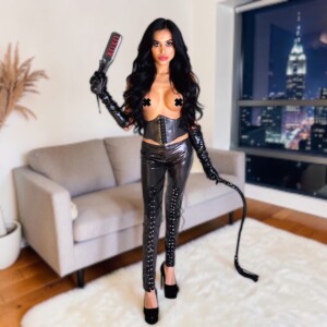 Person in black leather outfit with whip.
