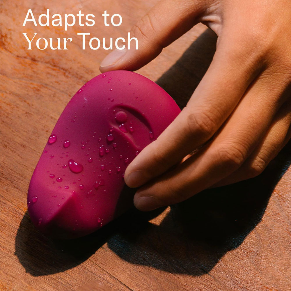 Hand holding pink textured ergonomic device