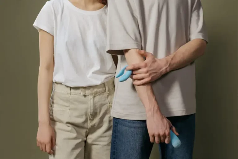 Couple holding curved blue objects discreetly.
