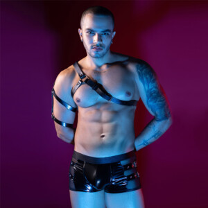 Tattooed man in black leather harness and shorts