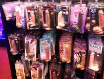 Close-up of sex toy shelf featuring male masturbators, vibrating dildos, and strap-on toys at Romantic Depot Manhattan