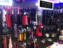 Wall of bondage restraints and BDSM accessories at Romantic Depot Manhattan including handcuffs, ropes, paddles, and collars for fetish enthusiasts.