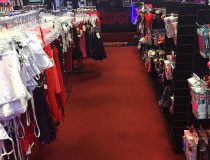 Lingerie wall display at Romantic Depot Manhattan featuring sexy outfits, lace teddies, and intimate accessories