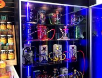 Smoke shop display at Romantic Depot Manhattan with a variety of glass pipes, rolling papers, vapes, and smoking accessories arranged on shelves.