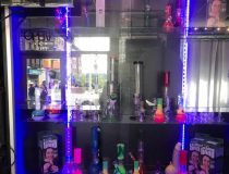 Display shelves at Romantic Depot Manhattan smoke shop showcasing bongs, glass pipes, grinders, and rolling trays.