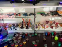 Romantic Depot Manhattan smoke shop section featuring glass pipes, rolling papers, and vape accessories for adult use.