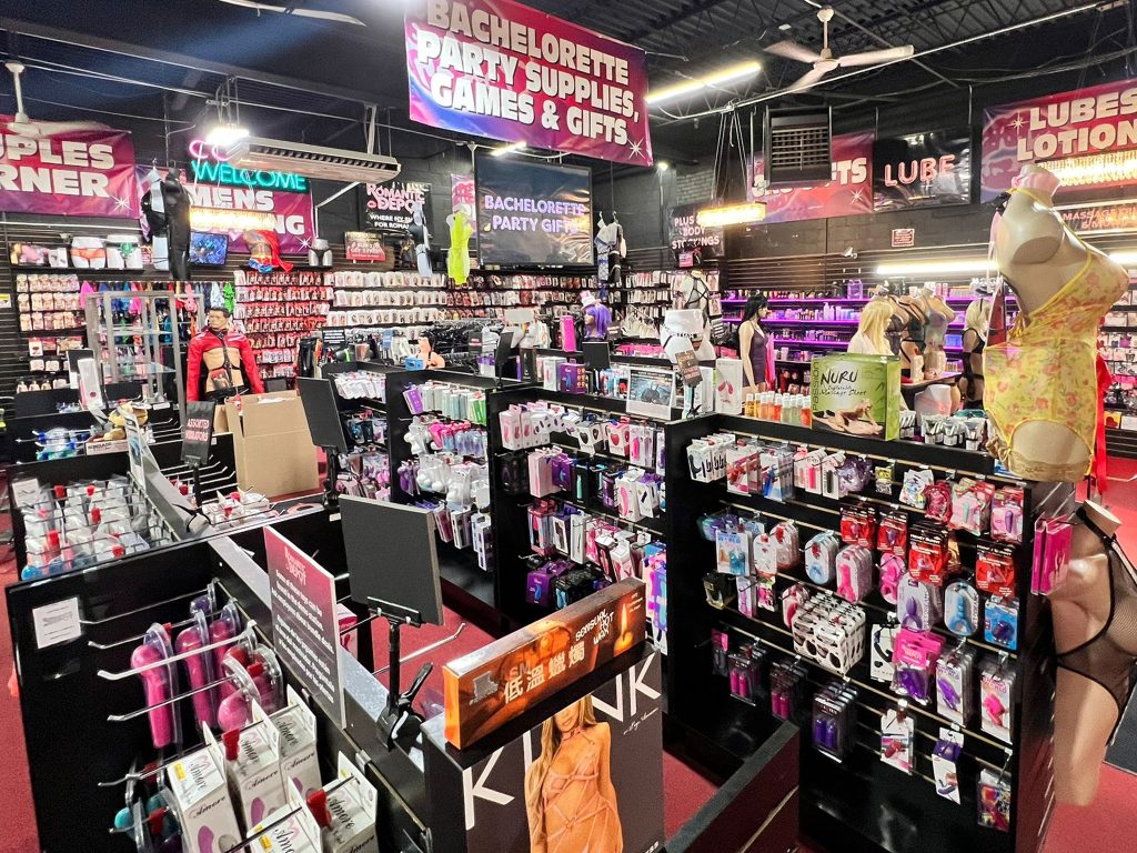 Inside Romantic Depot store featuring vibrators, lubes, lingerie, kink gear, and bachelorette party supplies in a colorful, fully stocked layout