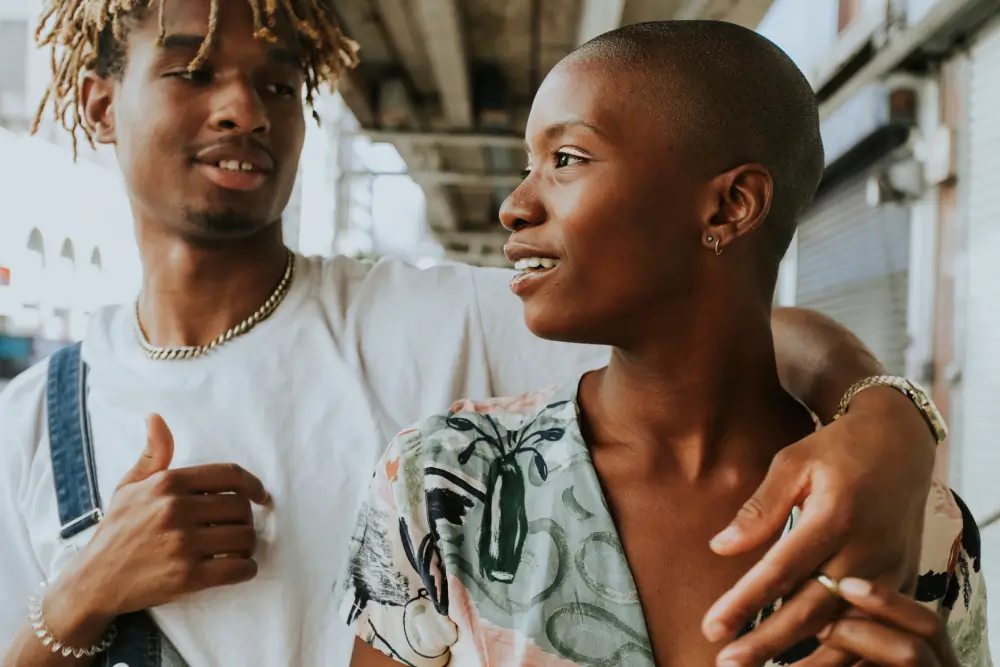 Black couple sharing a joyful moment under an urban overpass, symbolizing love, connection, and freedom during Juneteenth and Pride Month in NYC.